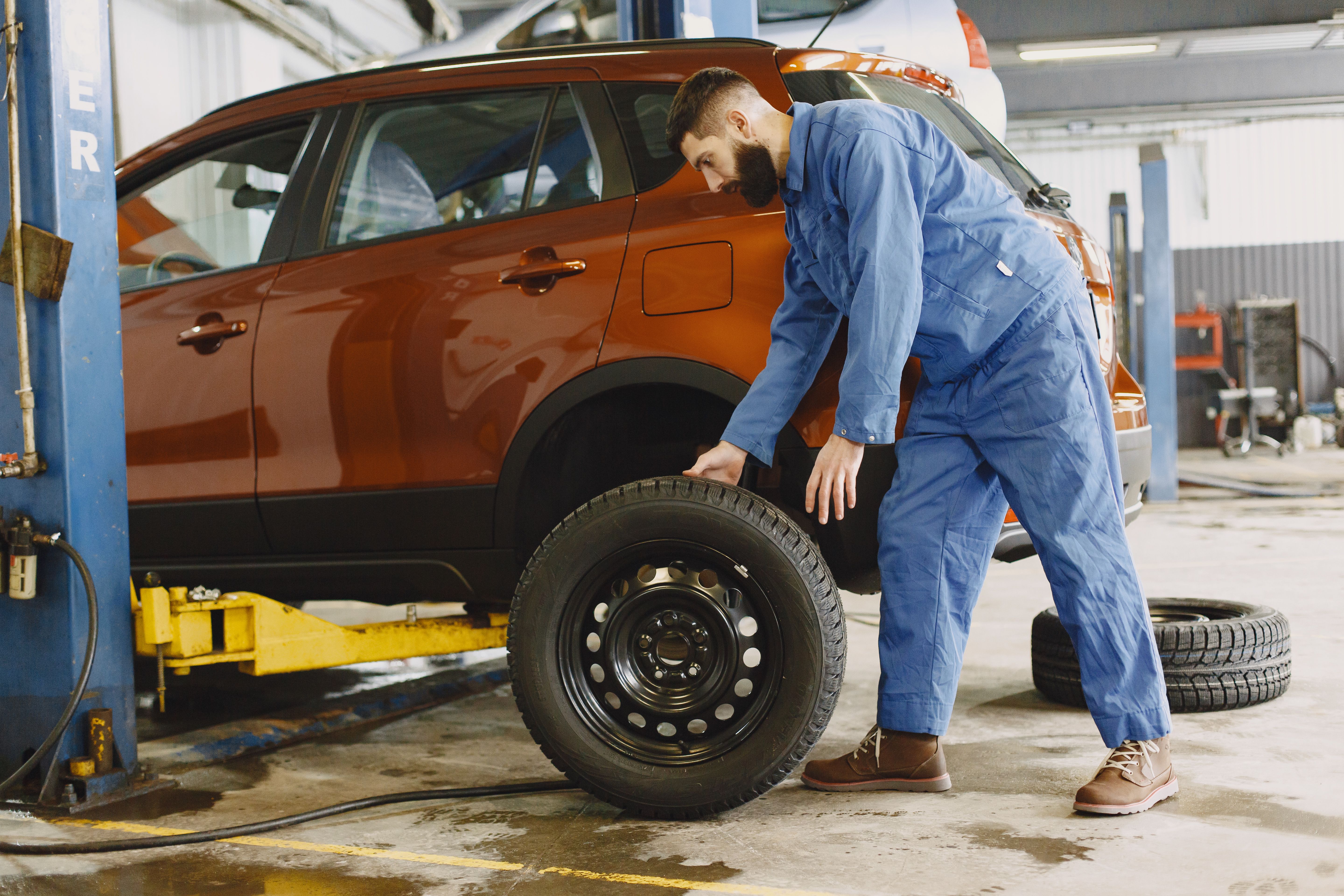 Professional tire service technician working on vehicle